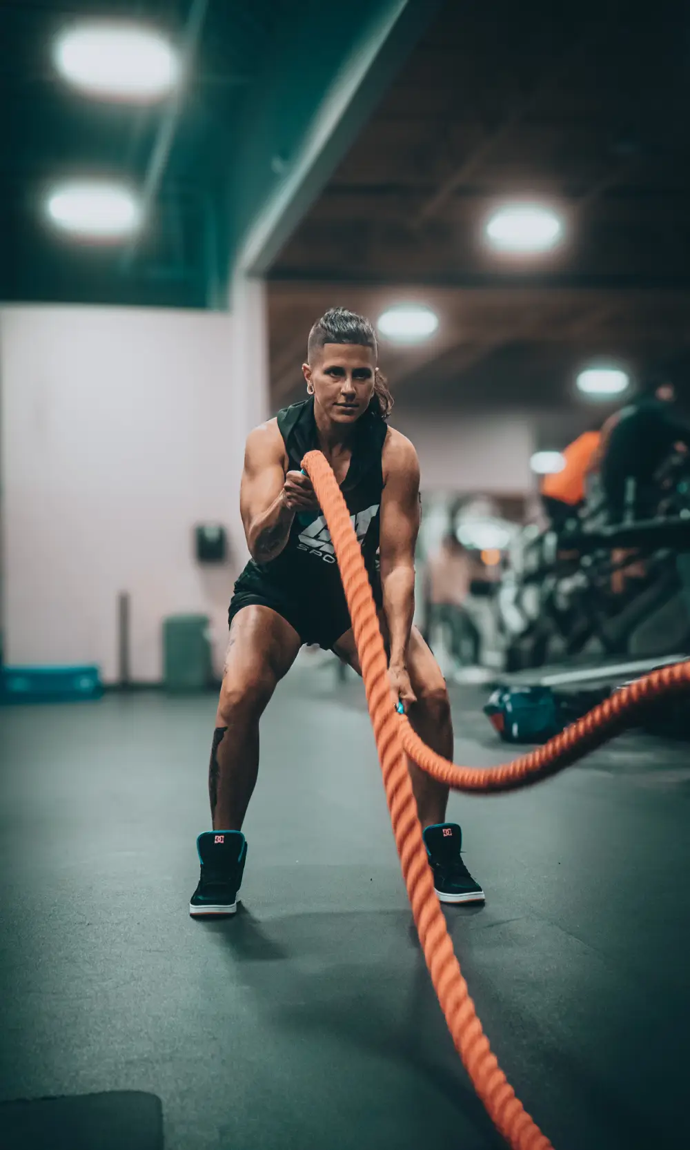 An athlete training with battle ropes in a gym